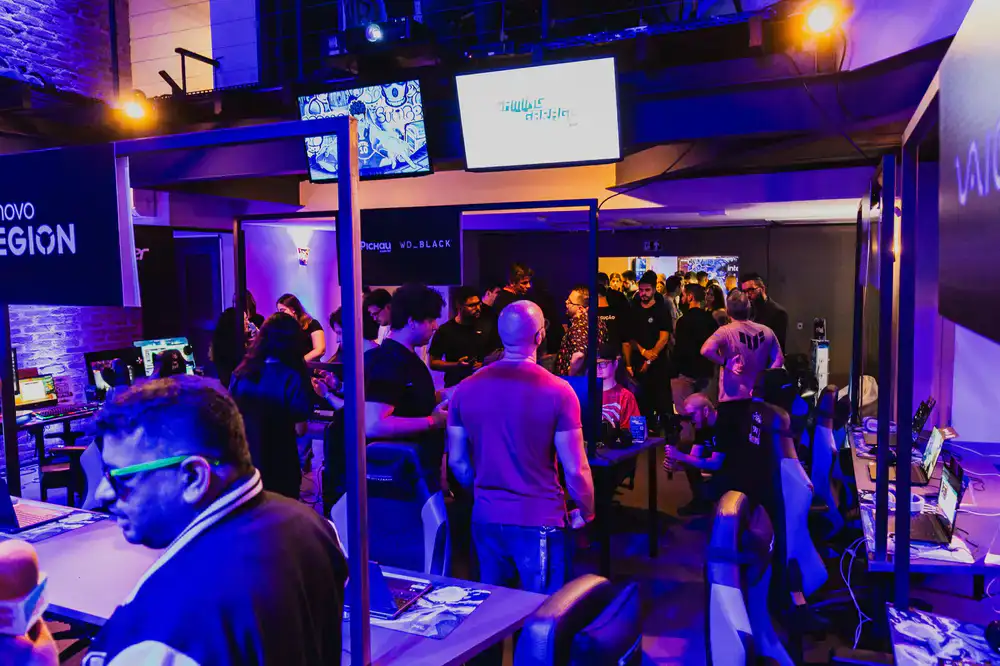 Players gathered closely around an arcade setup, focused on the screen